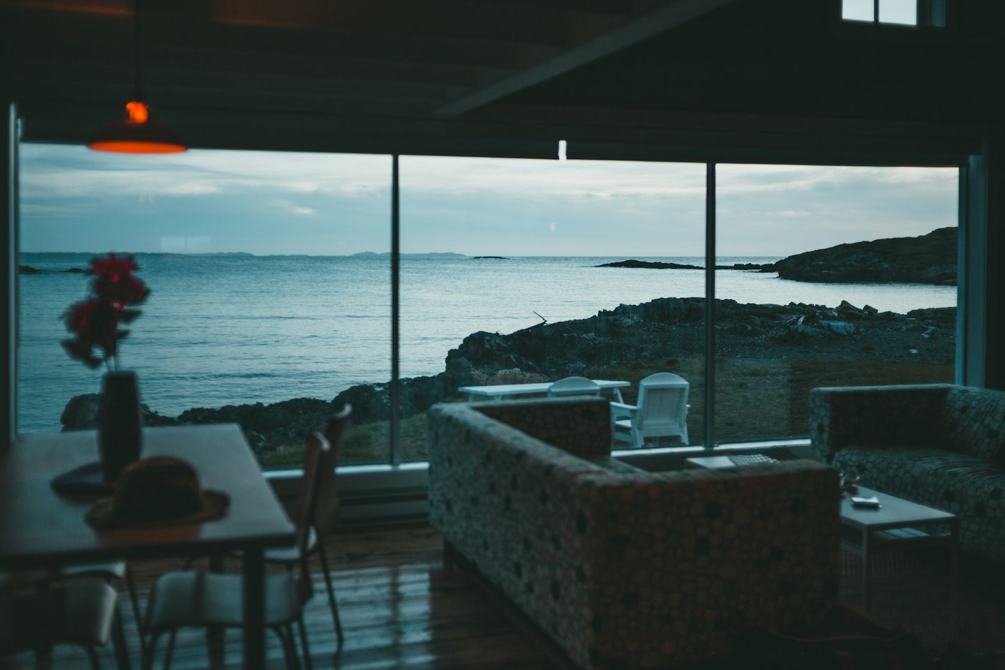 Soggiorno accogliente con vista su una costa rocciosa e un oceano calmo.