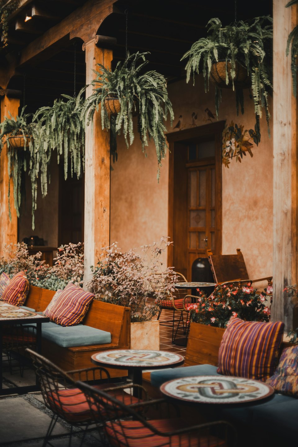 Terrazza esterna con piante e tavoli in mosaico.